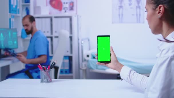 Beyaz önlüklü doktor akıllı telefon tutuyor. — Stok video