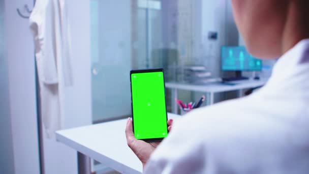 Médico médico olhando para o telefone com tela verde — Vídeo de Stock