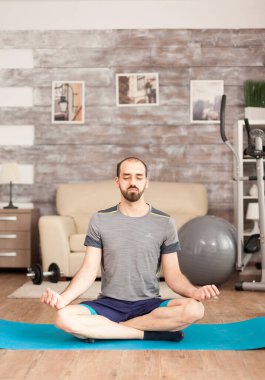 Yoga yapan bir adam gözlerini kapalı tutuyor.