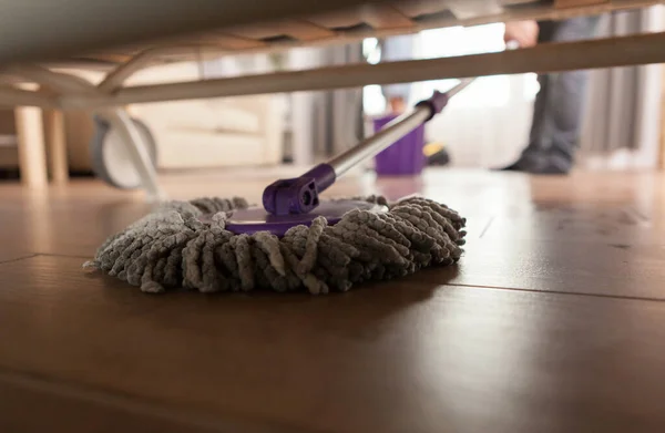 Mopping debajo del sofá — Foto de Stock