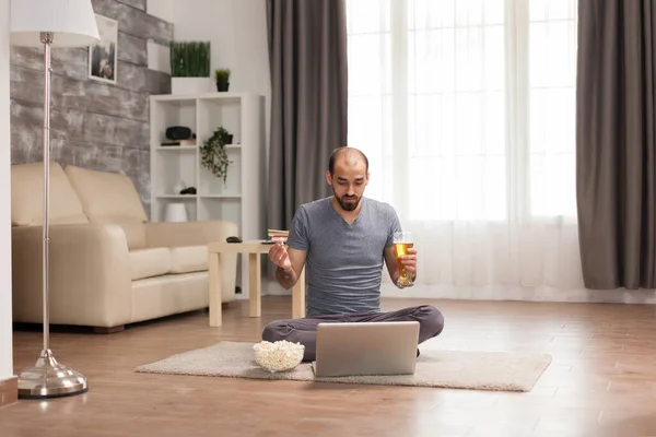 Fröhlicher Mann hält Bier und isst Popcorn — Stockfoto