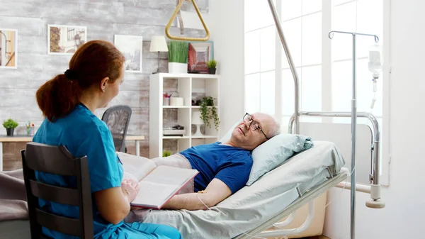 Vecchio malato in pensione sdraiato in un letto d'ospedale in una casa di cura — Foto Stock