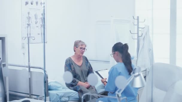 Senior patient in hospital bed talking with nurse — Stock Video