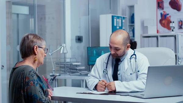 Doktor yaşlı, emekli bir kadına danışıyor. — Stok fotoğraf