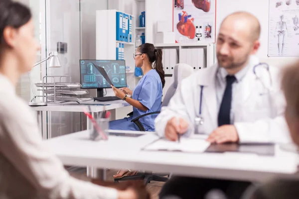 Медсестра осматривает рентген пациента — стоковое фото
