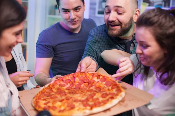 Close up friends at a party excited about delicious pizza — Stock Photo, Image