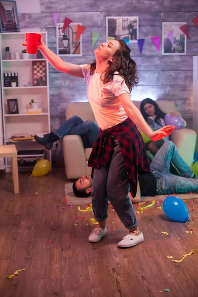 Молодая женщина танцует одна на вечеринке друзей — стоковое фото