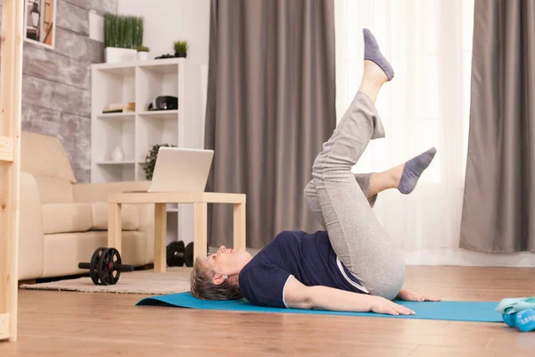 Old woman exercising in her apartment