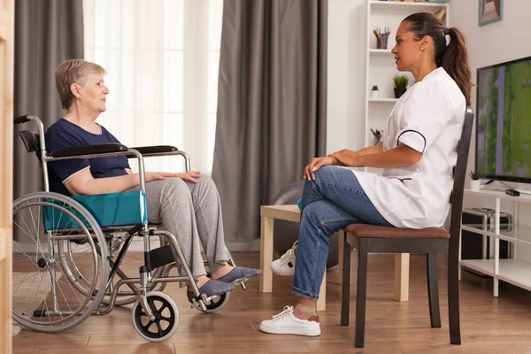 Cuidador hablando con una mujer discapacitada — Foto de Stock