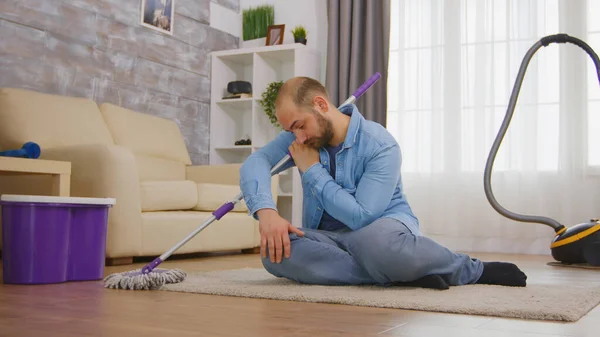 Hombre cansado sentado en una alfombra acogedora — Foto de Stock