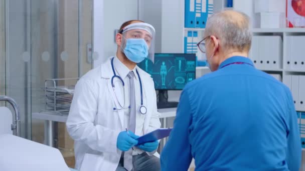Médico consultando al paciente durante COVID 19 — Vídeos de Stock