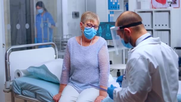 Anciana firmando el formulario médico — Vídeo de stock