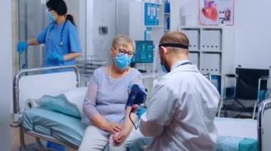 Doktor hipertansiyon hastasını kontrol ediyor