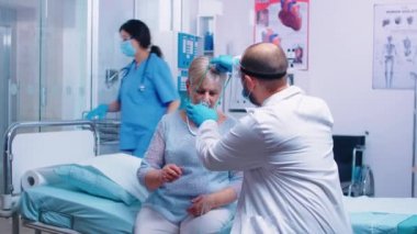 Doktor oksijen maskesi takıyor.
