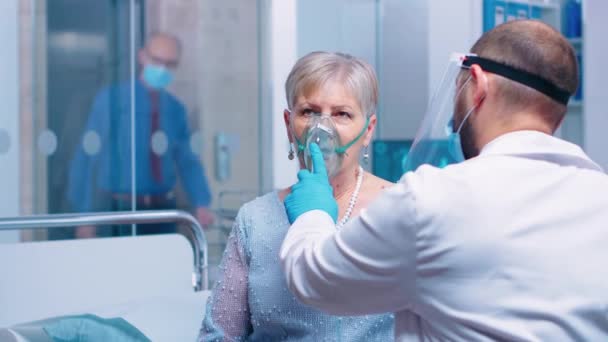 Lekarz w masce pomaga staruszce oddychać. — Wideo stockowe