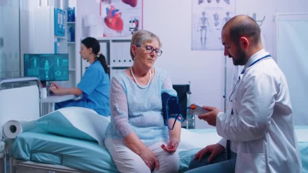 Sjuksköterska skriver blodtryck nivåer — Stockvideo