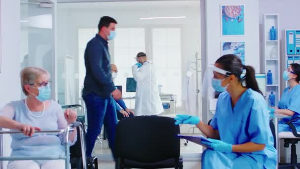 Médico en sala de examen escuchando pulmones de pacientes mayores con estetoscopio — Vídeos de Stock