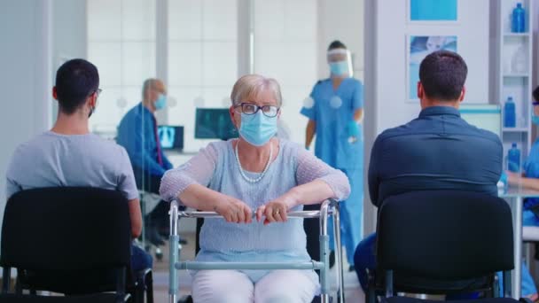 Ανώτερη γυναίκα με περιπατητή στην αίθουσα αναμονής του νοσοκομείου — Αρχείο Βίντεο