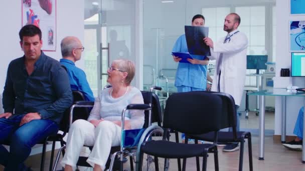 Медсестра дивиться на рентгенографію під час розмови з лікарем — стокове відео