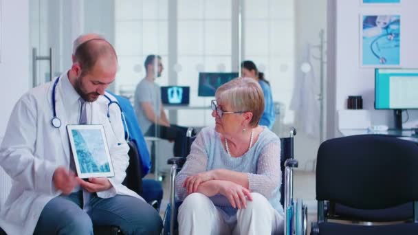 Médecin expliquant le diagnostic à une femme âgée en fauteuil roulant — Video