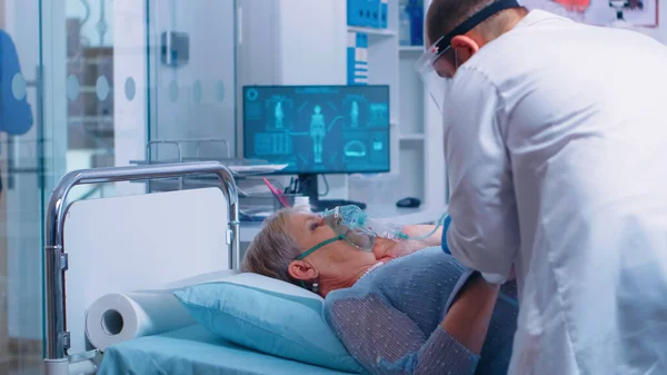 Arzt setzt Seniorin Sauerstoffmaske auf — Stockfoto