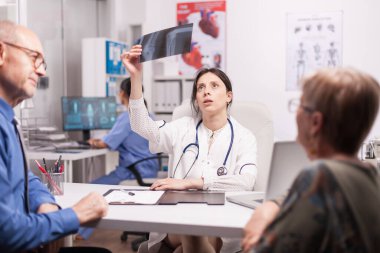 Endişeli doktor röntgeni inceliyor.