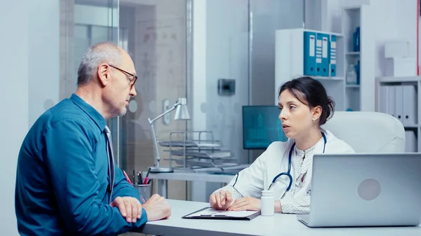 Elderly retired man consulting with doctor — Stock Photo, Image