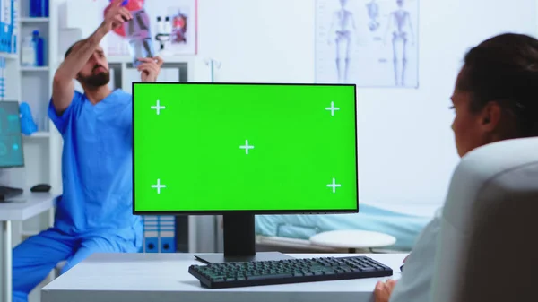 博士在有绿色屏幕的电脑上工作 — 图库照片