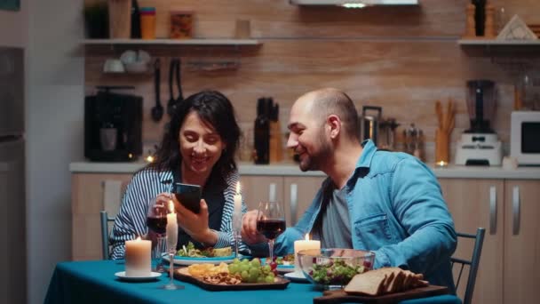 Pareja usando el teléfono durante la cena — Vídeos de Stock