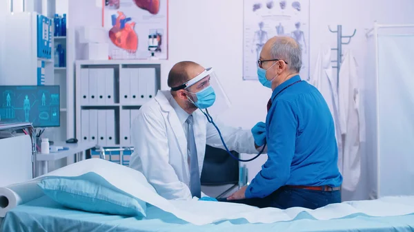 Doctor listening heart of senior patient — Stock Photo, Image