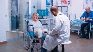 Dijital tabletli doktor tedavi kliniğinde tıbbi danışmanlık yapıyor
