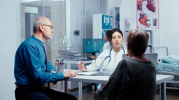 Young physician consulting old retired couple — Stock Photo, Image