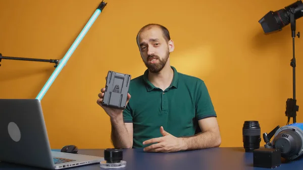 Content creator holding v mount batteri