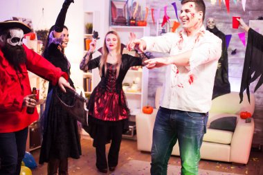 Dans figürlerini gösteren zombi gibi giyinmiş bir adam.