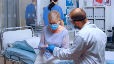 Sağlık formunu imzalayan yaşlı kadın.