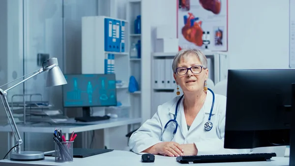 Femme expérimentée médecin senior souriant à la caméra — Photo