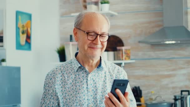 Idős férfi, telefonnal a kezében mosolyog. — Stock videók