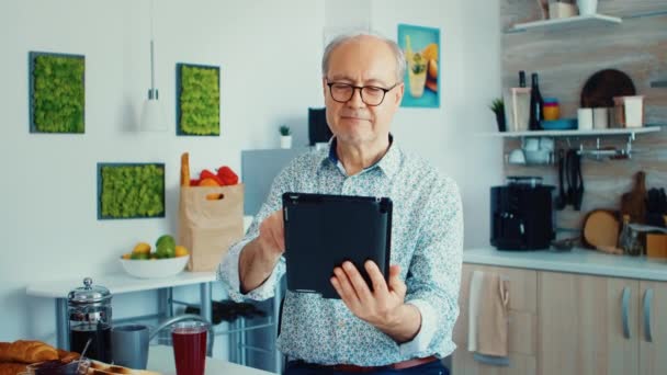Starší muž držící tabletu ks — Stock video