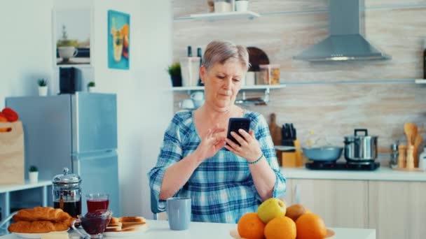 Mujer mayor surfeando en el teléfono moderno — Vídeo de stock