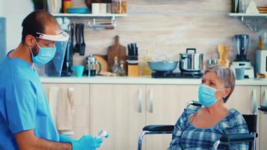 Kızılötesi termometre kullanan sosyal hizmet görevlisi