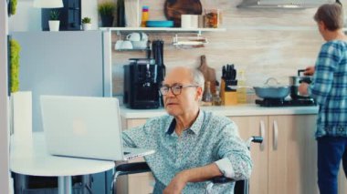 Dizüstü bilgisayarda çalışan yaşlı engelli