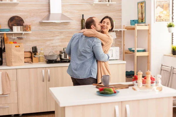 Uomo baciare moglie in cucina — Foto Stock