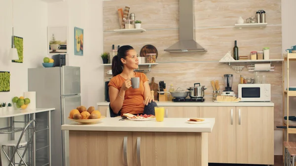 Rahatlıyor ve kahve içiyor.