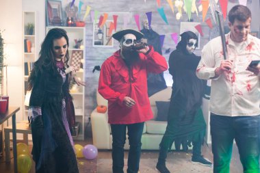 Baltayla zombi gibi giyinmiş bir adam.