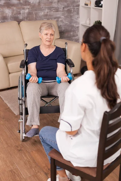Donna sulla sedia a rotelle discutendo con l'infermiera — Foto Stock