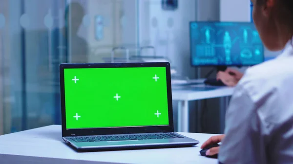 Hälso- och sjukvårdspersonal som använder bärbar dator med grön skärm — Stockfoto