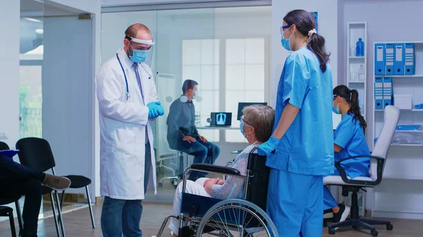 Discussing with disabled senior woman during COVID pandemic — Stock Photo, Image