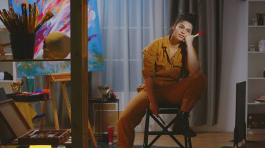 Sanat stüdyosundaki düşünceli ressam.