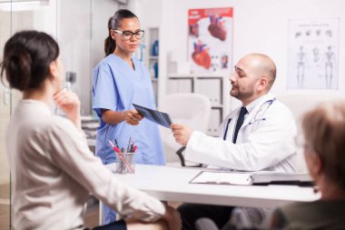 Doktor hemşirenin röntgen görüntüsünü tutuyor.