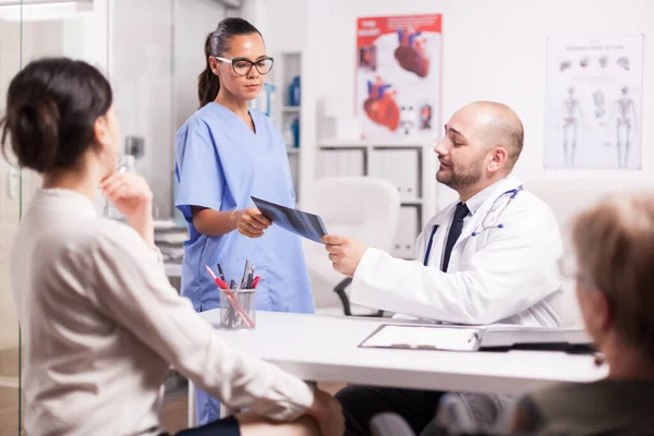 Doktor hemşirenin röntgen görüntüsünü tutuyor. — Stok fotoğraf